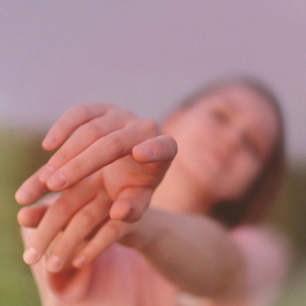Person stretching gently against a minimalist background.